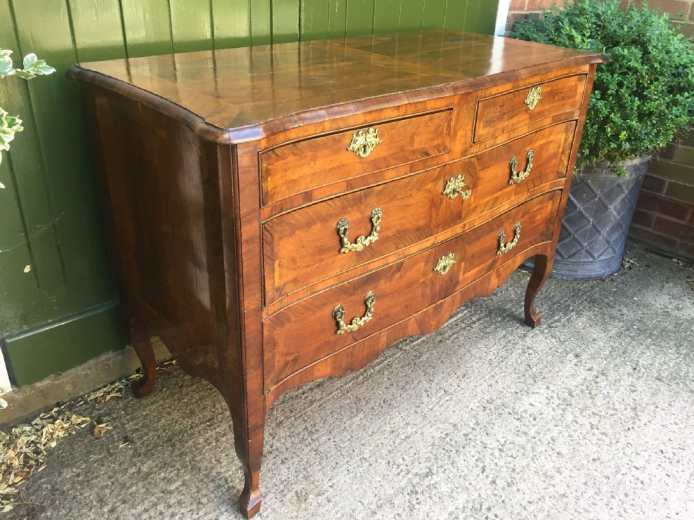 A mid-18th-century Italian serpentine commode with parquetry olive wood and walnut veneers and ornate brass mounts. View VII