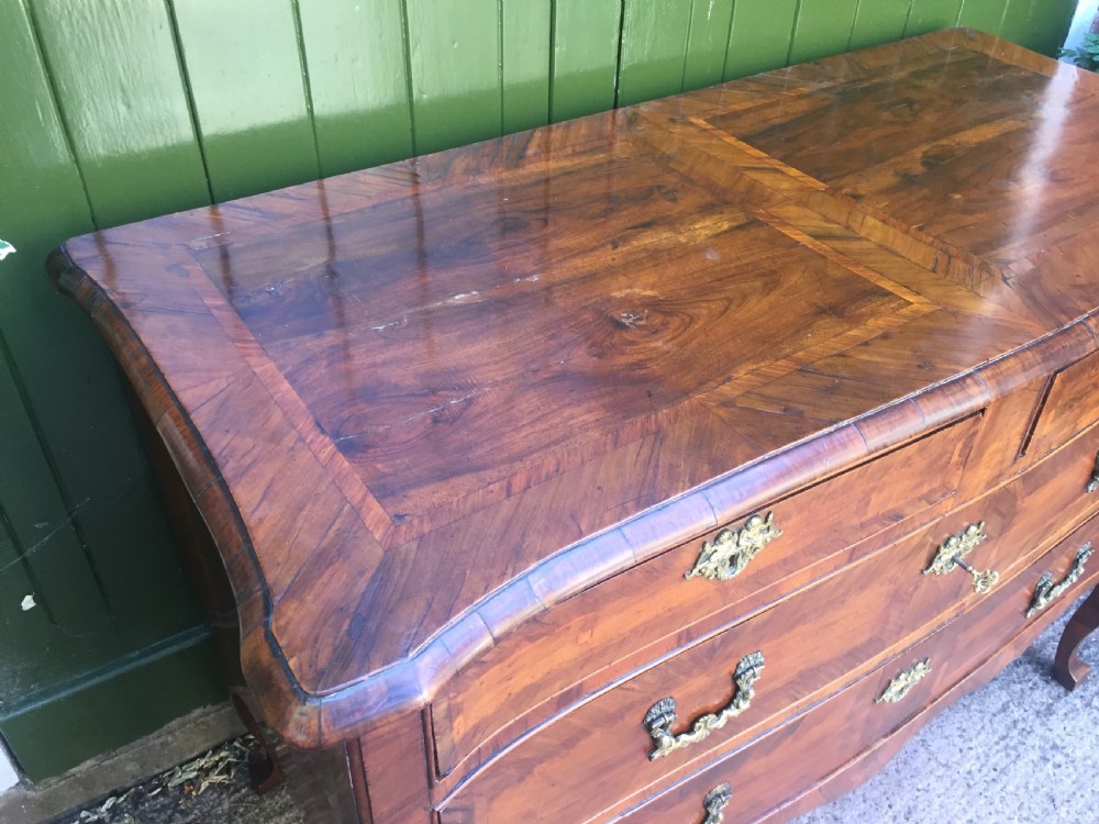 A mid-18th-century Italian serpentine commode with parquetry olive wood and walnut veneers and ornate brass mounts. View VIII