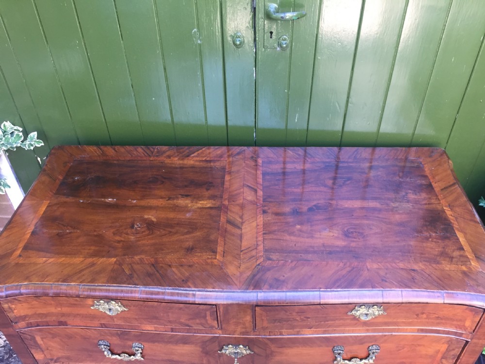 A mid-18th-century Italian serpentine commode with parquetry olive wood and walnut veneers and ornate brass mounts. View IX