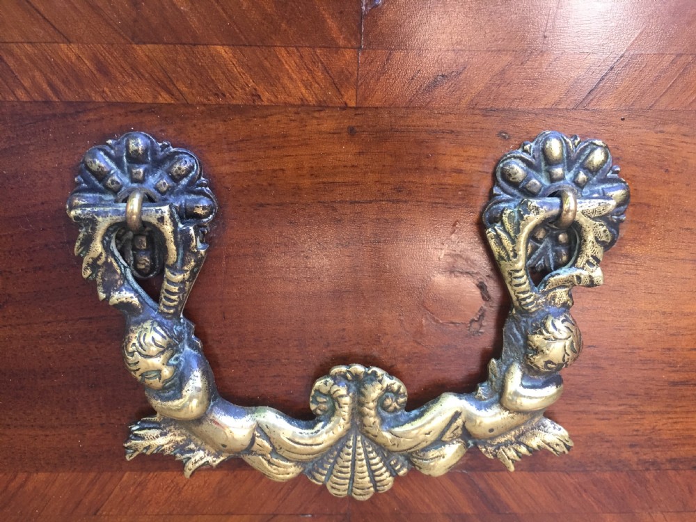 A mid-18th-century Italian serpentine commode with parquetry olive wood and walnut veneers and ornate brass mounts. View X
