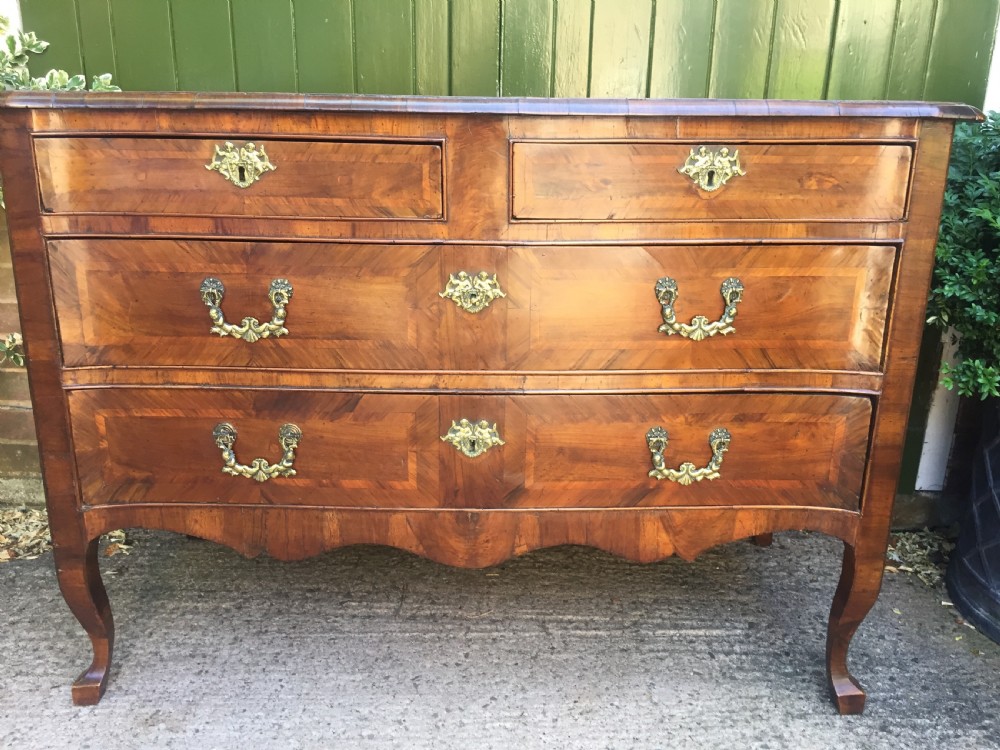 A mid-18th-century Italian serpentine commode with parquetry olive wood and walnut veneers and ornate brass mounts. View XI