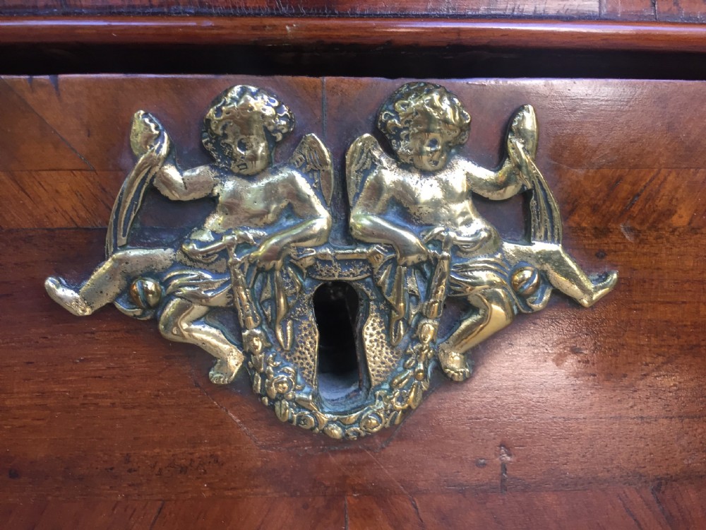 A mid-18th-century Italian serpentine commode with parquetry olive wood and walnut veneers and ornate brass mounts. View XII
