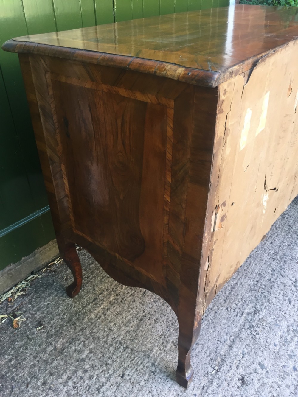 A mid-18th-century Italian serpentine commode with parquetry olive wood and walnut veneers and ornate brass mounts. View XXI