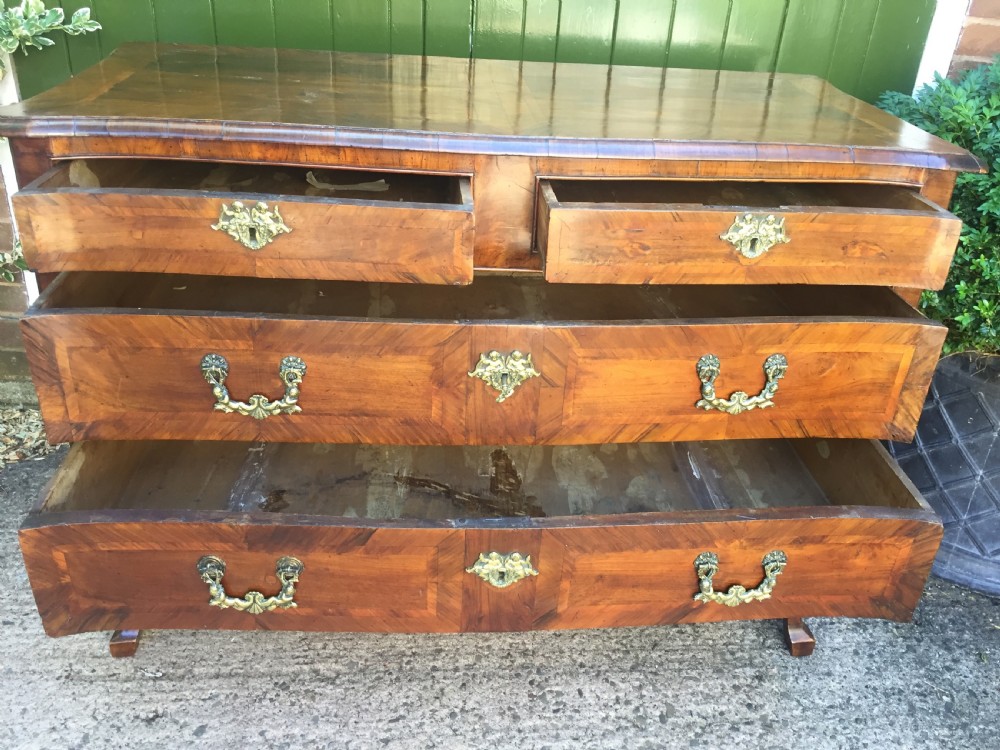 A mid-18th-century Italian serpentine commode with parquetry olive wood and walnut veneers and ornate brass mounts. View XXII