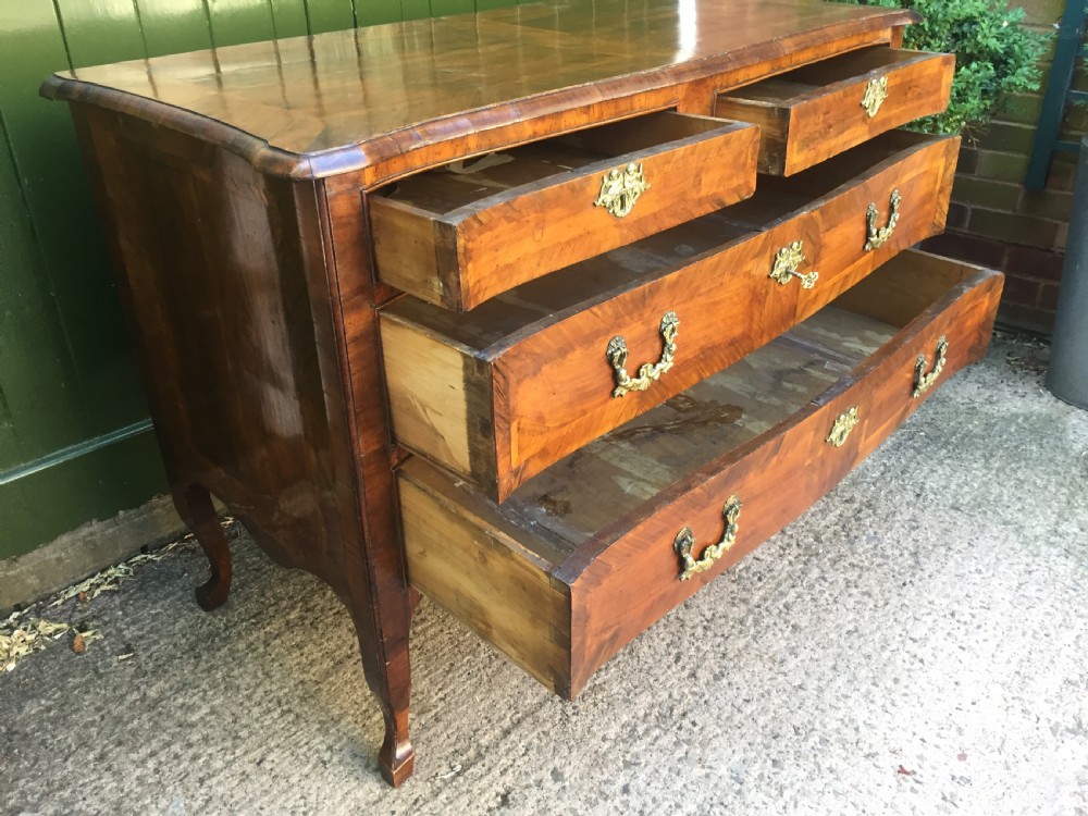A mid-18th-century Italian serpentine commode with parquetry olive wood and walnut veneers and ornate brass mounts. View XXIII