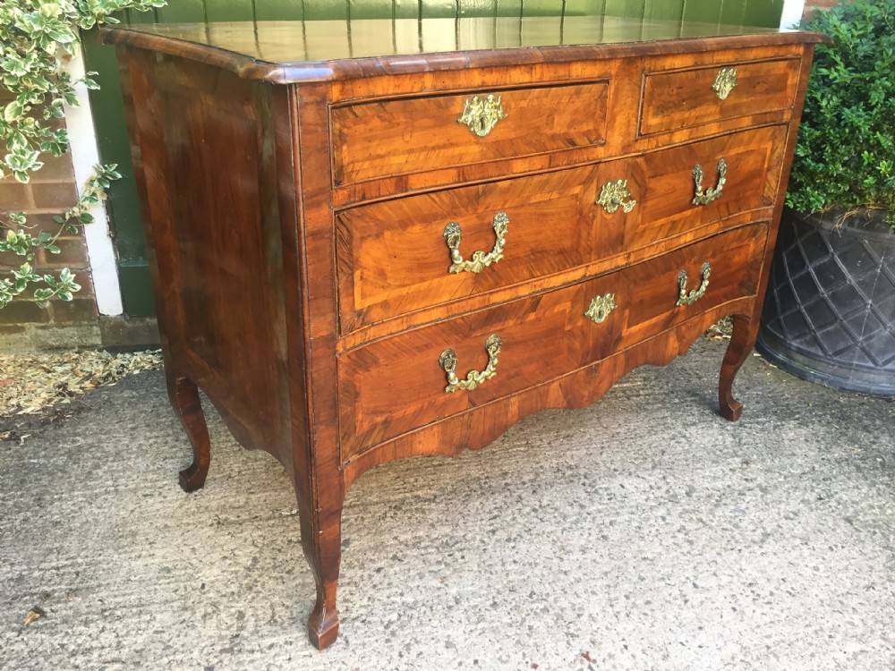 A mid-18th-century Italian serpentine commode with parquetry olive wood and walnut veneers and ornate brass mounts. View XXXI