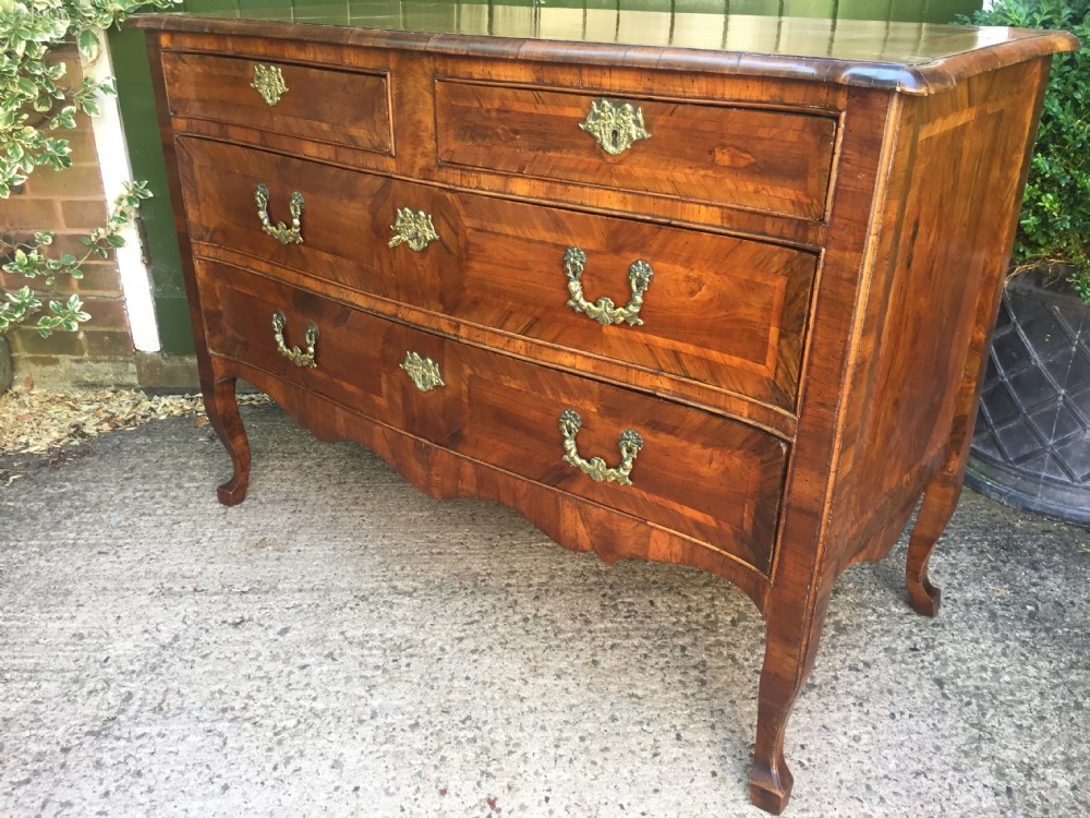 A mid-18th-century Italian serpentine commode with parquetry olive wood and walnut veneers and ornate brass mounts. View XXXII