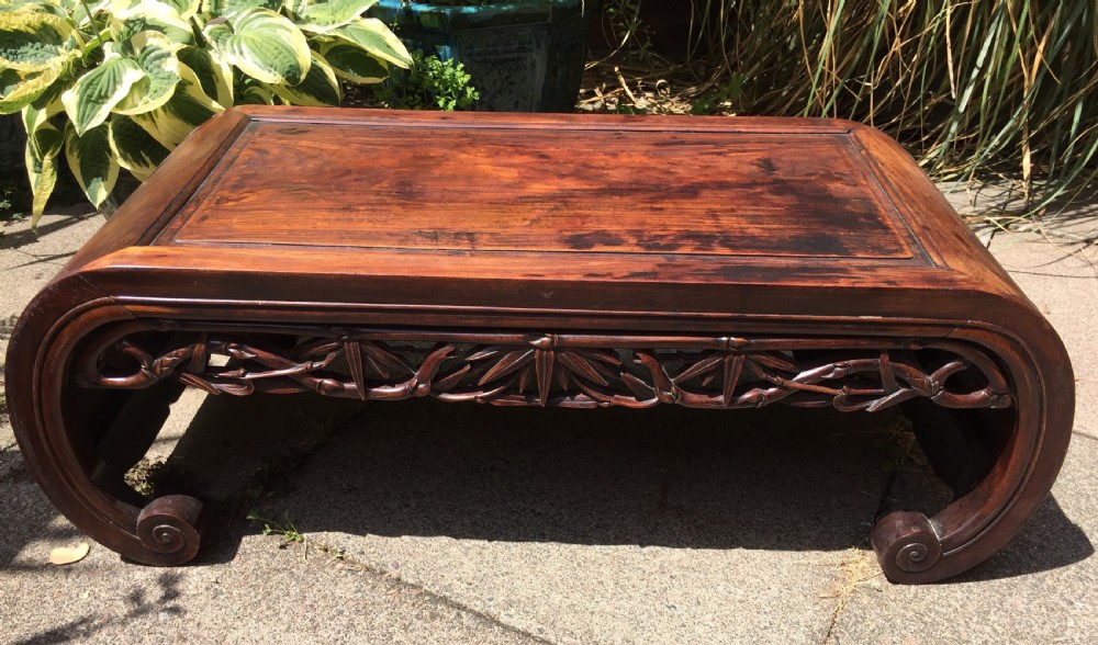 Late C19th Chinese Qing Dynasty carved hardwood 'kang' or opium table of scroll-end design.
