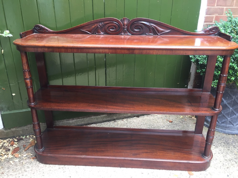 An early 19th-century George IV three-tier mahogany buffet featuring a carved scroll backboard, turned column supports, and a solid plinth base. View III