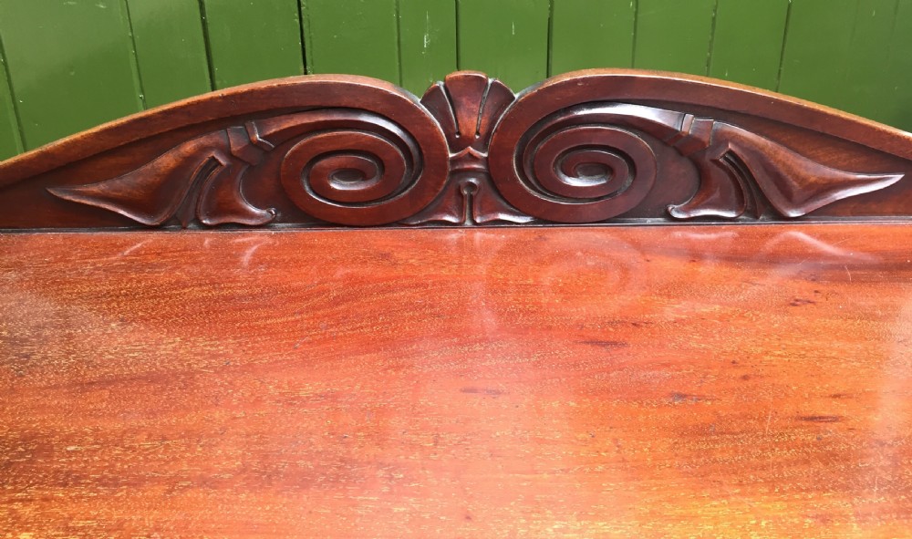 An early 19th-century George IV three-tier mahogany buffet featuring a carved scroll backboard, turned column supports, and a solid plinth base. View XI