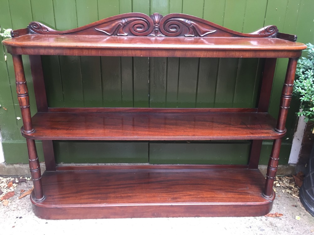 An early 19th-century George IV three-tier mahogany buffet featuring a carved scroll backboard, turned column supports, and a solid plinth base. View XV