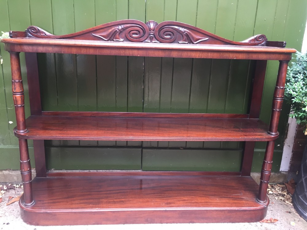 An early 19th-century George IV three-tier mahogany buffet featuring a carved scroll backboard, turned column supports, and a solid plinth base. View XVI
