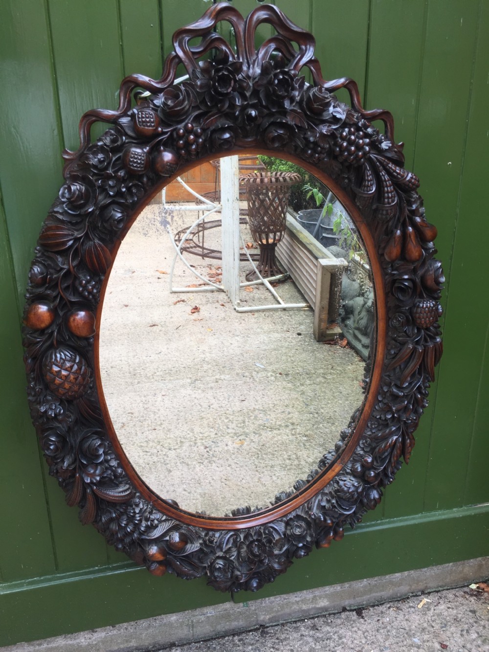 Exceptional mid C19th Indo-Portuguese carved rosewood or padauk framed oval mirror.