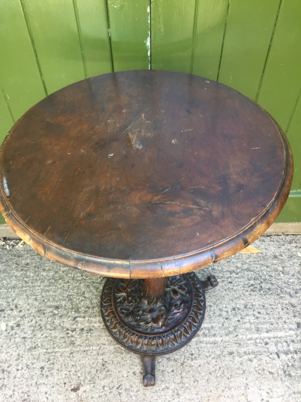 A late nineteenth-century dark brown linden wood side table featuring a circular top supported by a carved tree-trunk stem and a foliage-adorned tripod base. View IX
