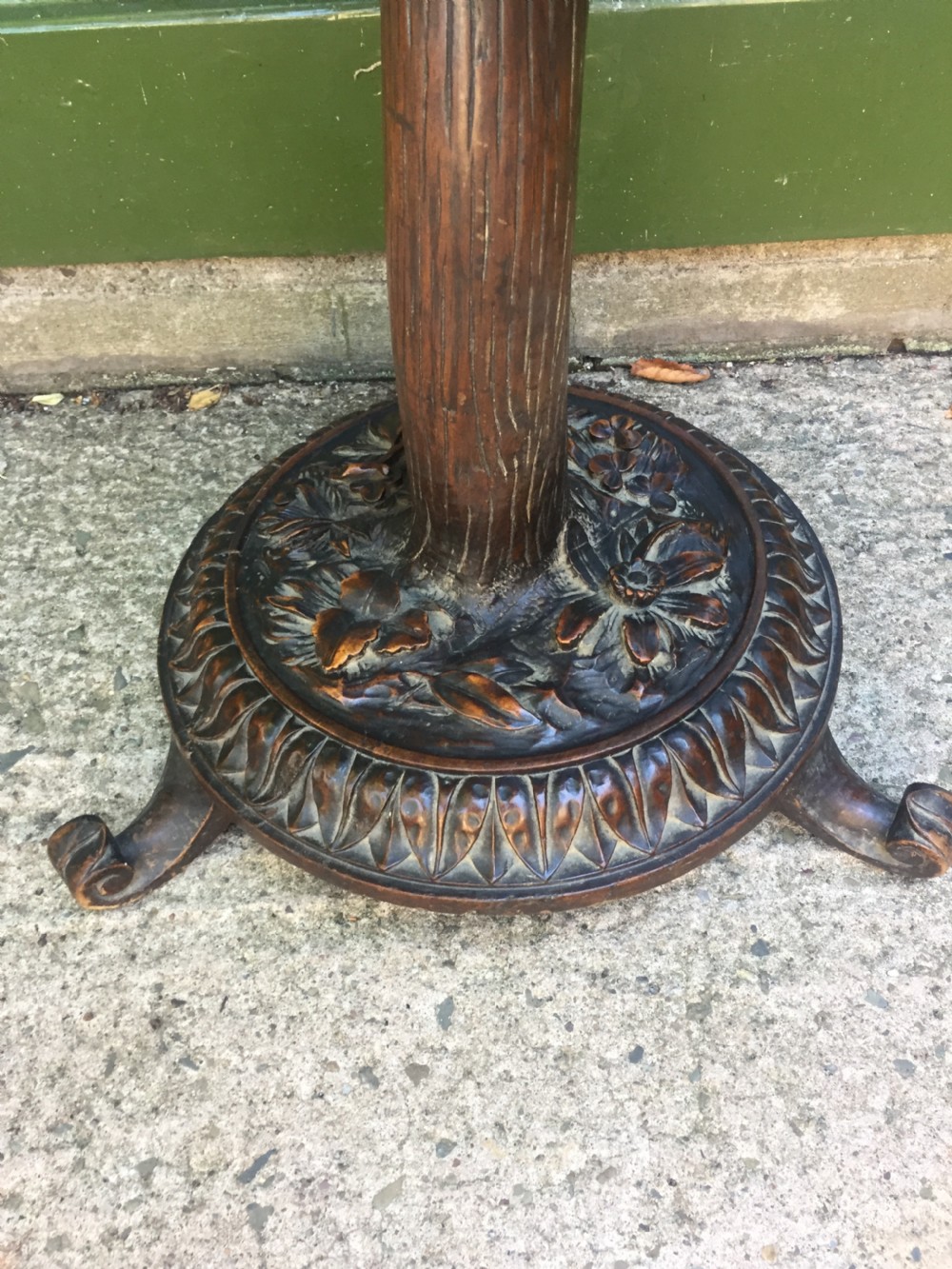 A late nineteenth-century dark brown linden wood side table featuring a circular top supported by a carved tree-trunk stem and a foliage-adorned tripod base. View XI
