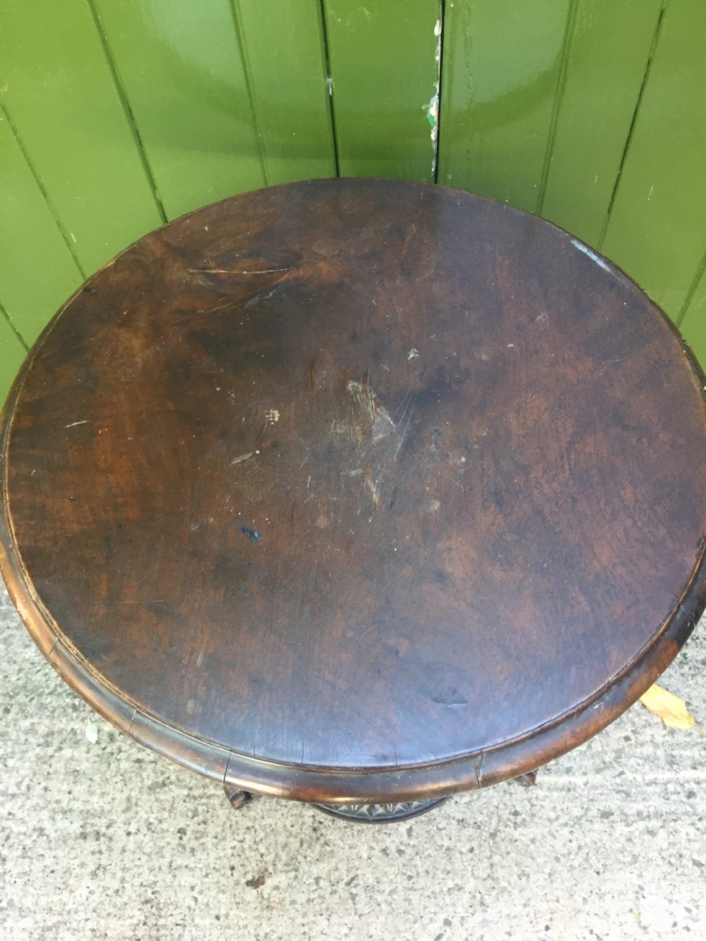 A late nineteenth-century dark brown linden wood side table featuring a circular top supported by a carved tree-trunk stem and a foliage-adorned tripod base. View XVIII
