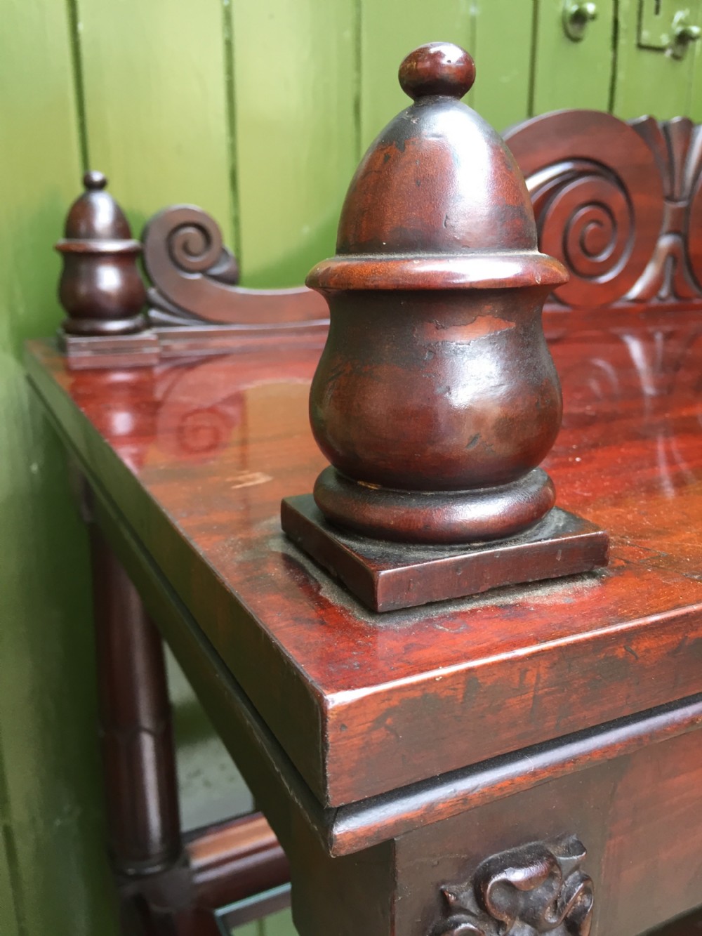 A George IV mahogany three-tier buffet featuring a carved scroll upstand, turned finials, column supports, and a glass-inset middle shelf. View VI