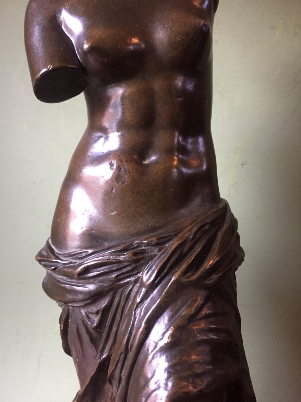 A late nineteenth-century dark bronze sculpture of the armless Venus de Milo standing on an integrated rectangular base. View IX