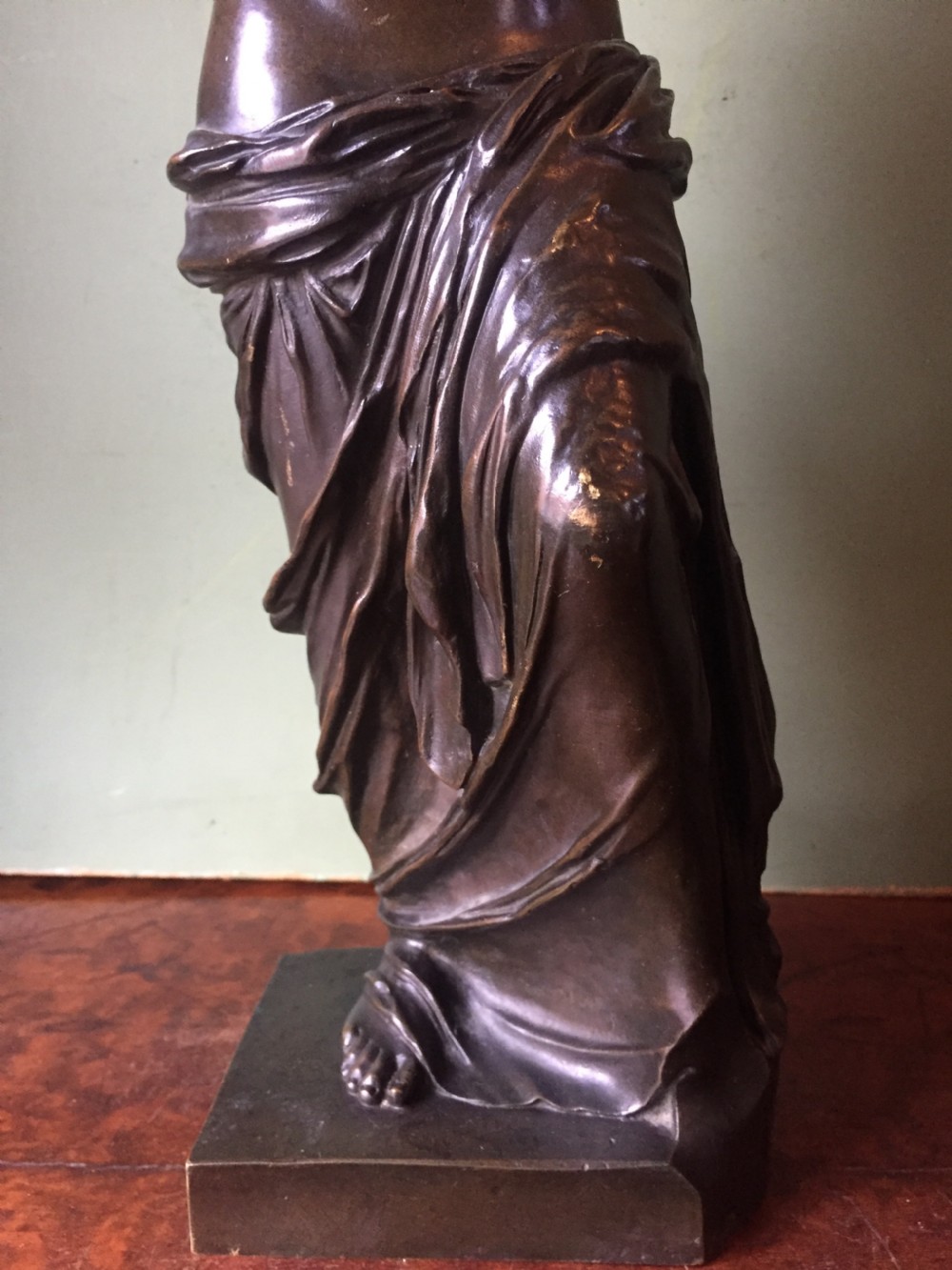 A late nineteenth-century dark bronze sculpture of the armless Venus de Milo standing on an integrated rectangular base. View X