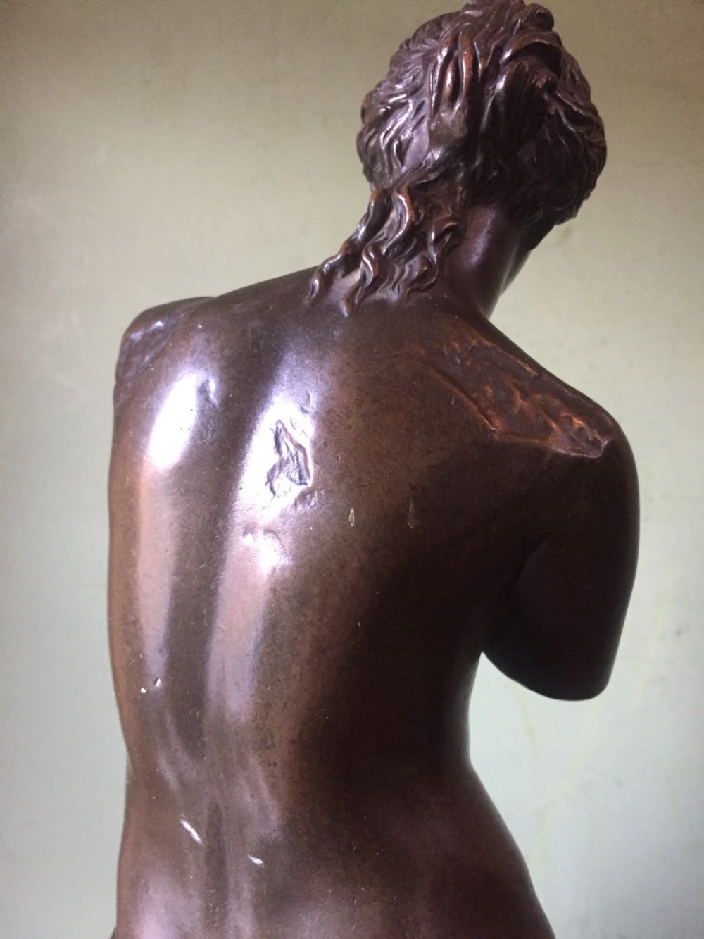 A late nineteenth-century dark bronze sculpture of the armless Venus de Milo standing on an integrated rectangular base. View XIV