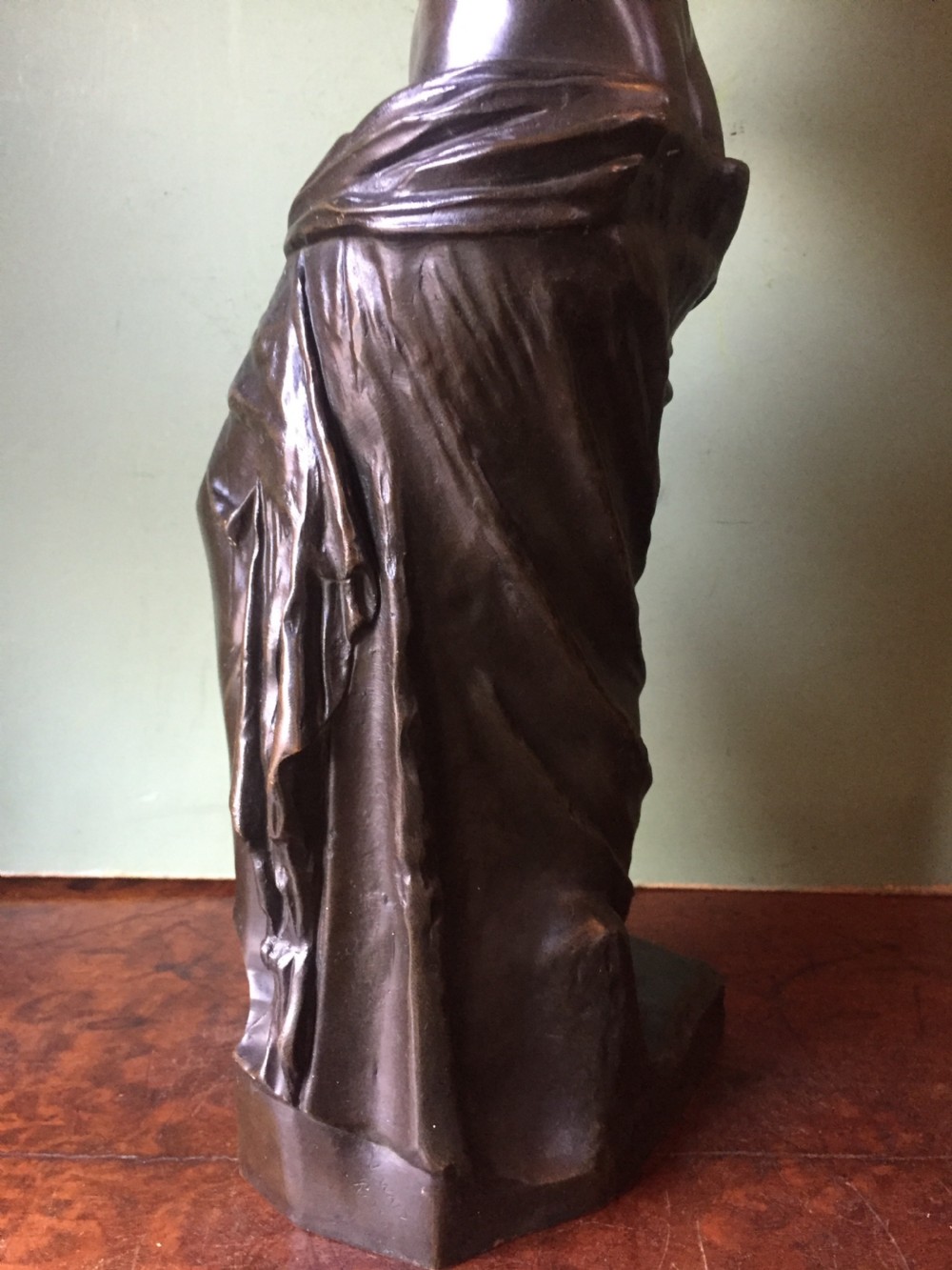 A late nineteenth-century dark bronze sculpture of the armless Venus de Milo standing on an integrated rectangular base. View XVI