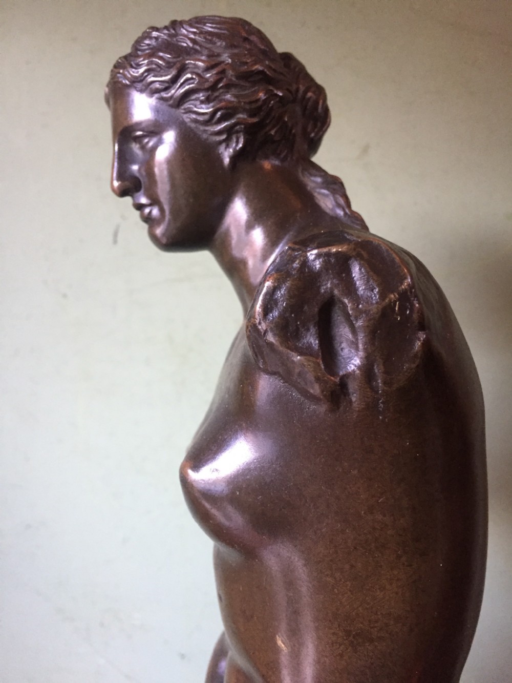 A late nineteenth-century dark bronze sculpture of the armless Venus de Milo standing on an integrated rectangular base. View XVII
