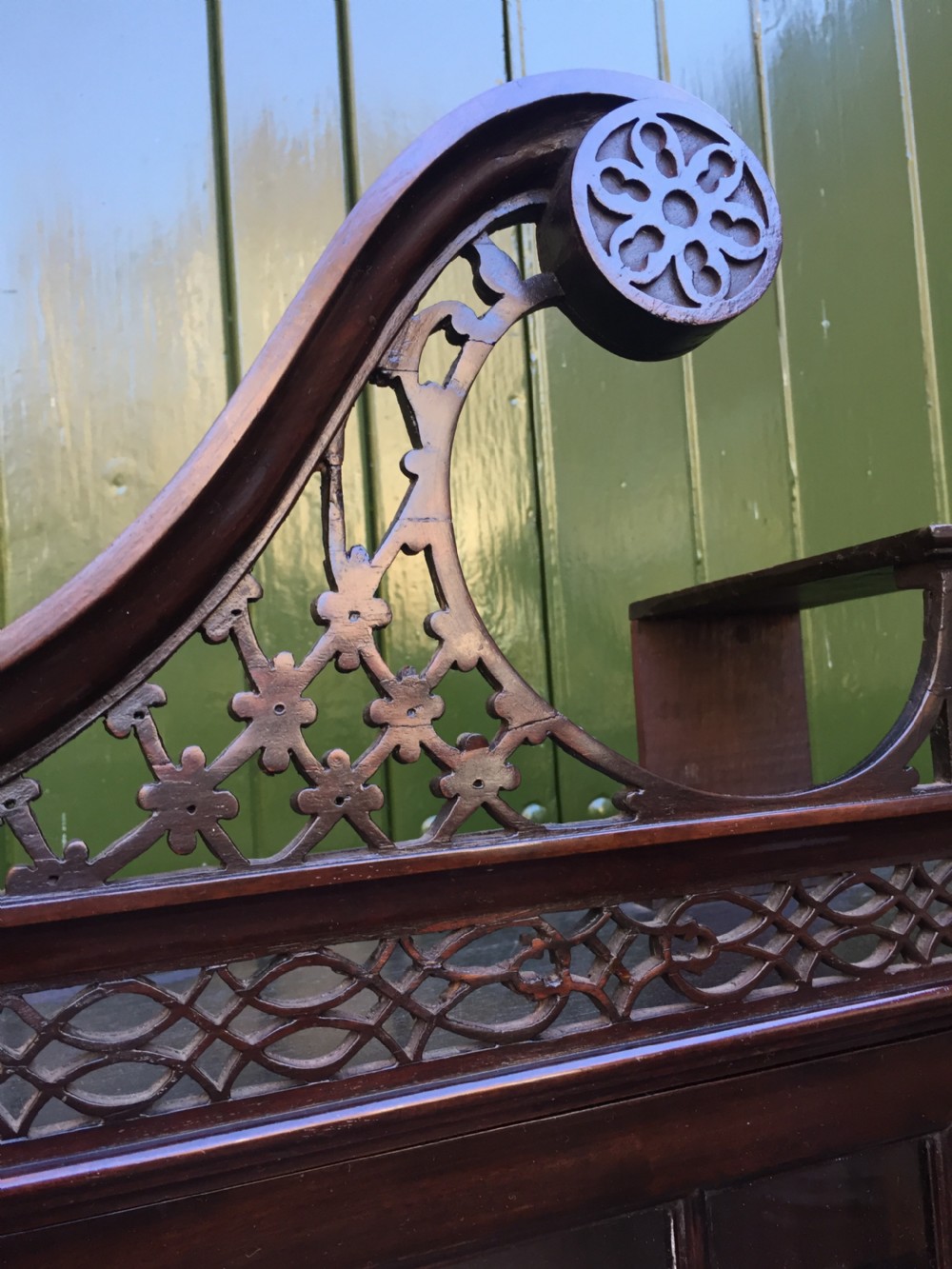 A late 19th-century Chippendale Revival mahogany glazed cabinet on stand featuring a swan-neck pediment, fretwork frieze, astragal glass doors, and turned legs with a lower shelf. View IX