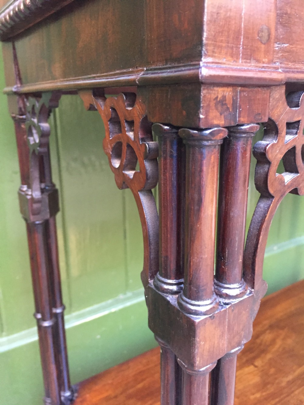 A late 19th-century Chippendale Revival mahogany glazed cabinet on stand featuring a swan-neck pediment, fretwork frieze, astragal glass doors, and turned legs with a lower shelf. View XII