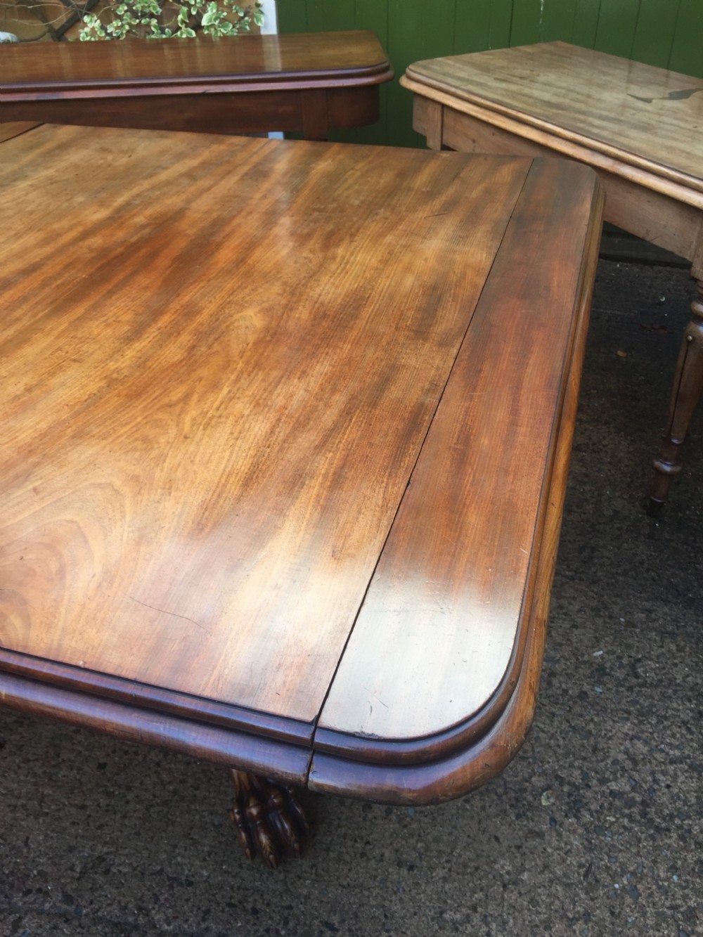 An early nineteenth-century George IV Irish mahogany extending dining table featuring a central pedestal base and turned support legs with brass castors. View VIII