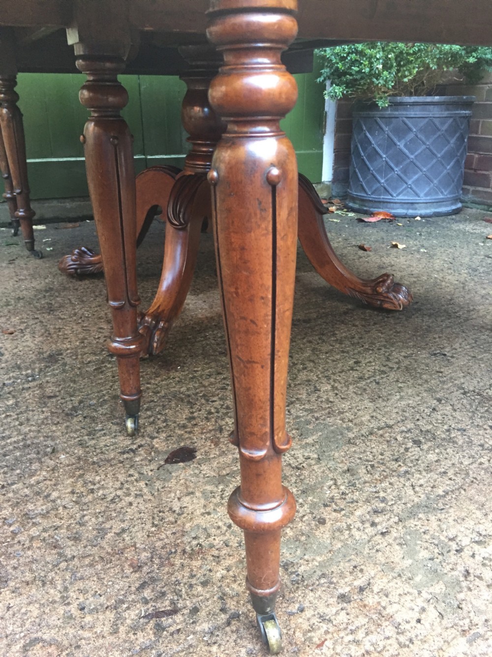 An early nineteenth-century George IV Irish mahogany extending dining table featuring a central pedestal base and turned support legs with brass castors. View XVII