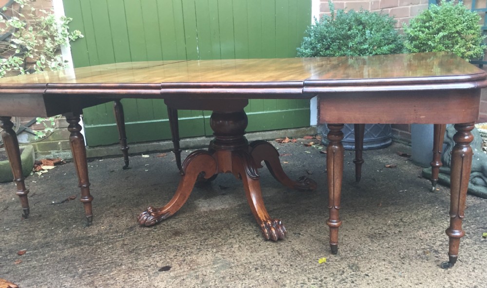 An early nineteenth-century George IV Irish mahogany extending dining table featuring a central pedestal base and turned support legs with brass castors. View XXII