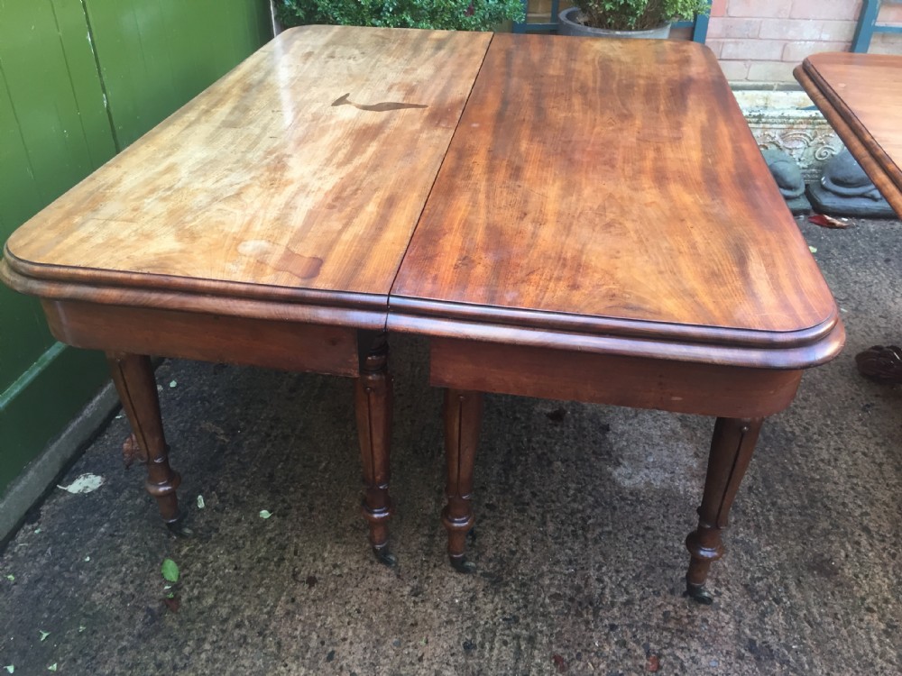 An early nineteenth-century George IV Irish mahogany extending dining table featuring a central pedestal base and turned support legs with brass castors. View III