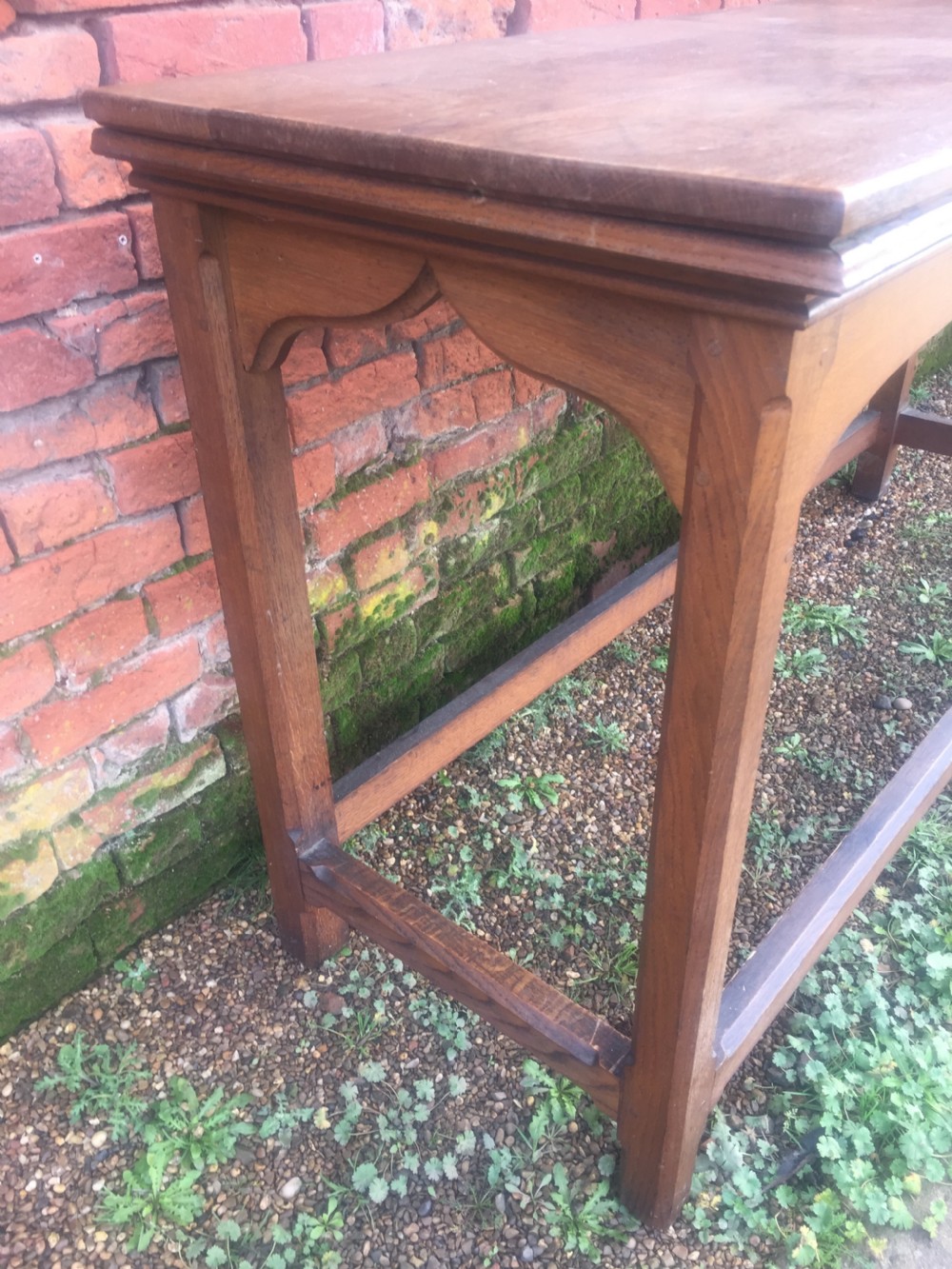 A rectangular oak serving table featuring a moulded top, shaped arched apron, square legs, and perimeter stretchers. View V
