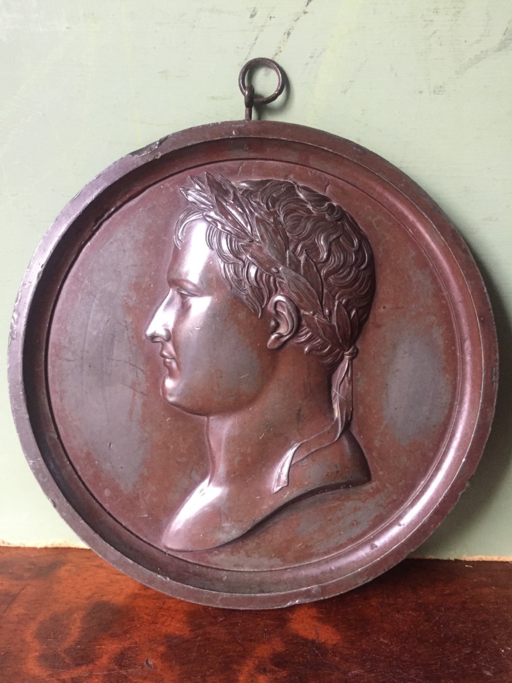 A pair of circular turned mahogany frames enclosing dark bronzed relief profile portraits of Napoleon and Marie-Louise under glass. View X