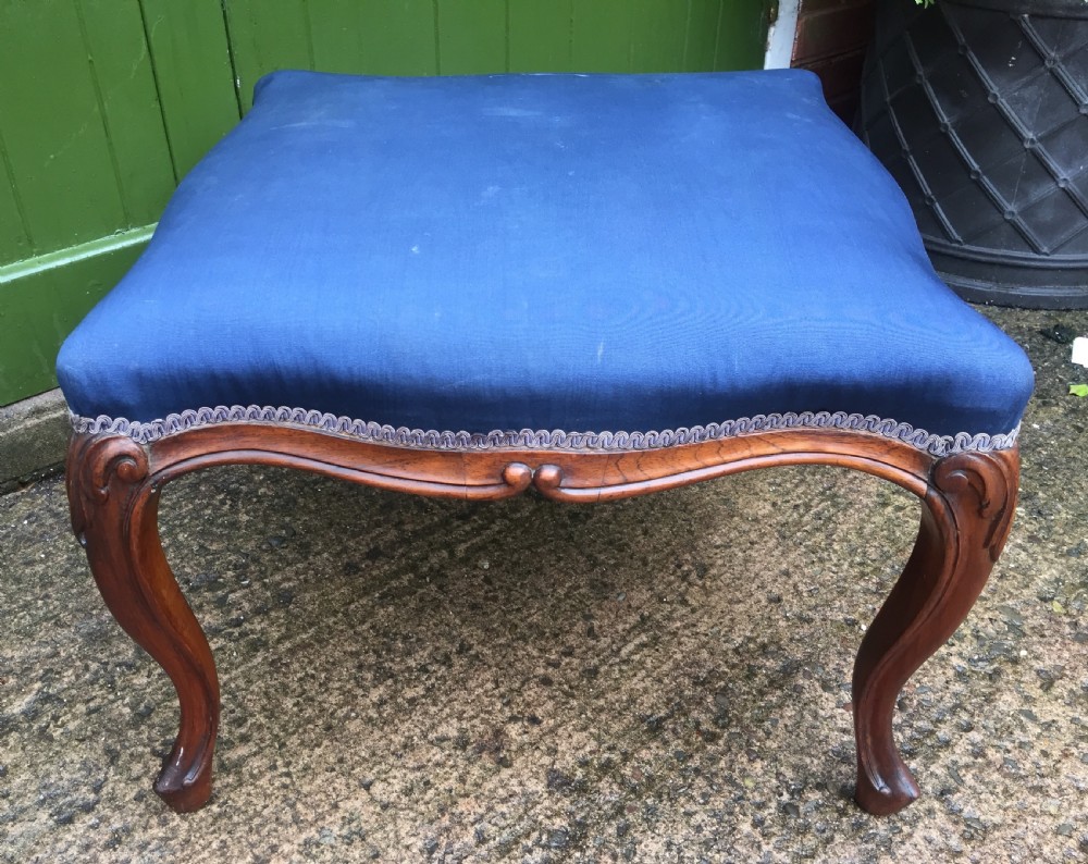 A large mid-nineteenth-century square Victorian stool featuring carved walnut cabriole legs and a blue upholstered top trimmed with gimp braid. View V