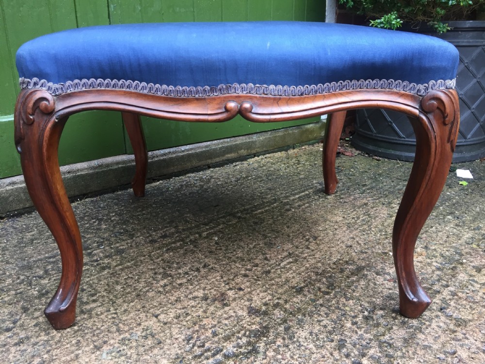 A large mid-nineteenth-century square Victorian stool featuring carved walnut cabriole legs and a blue upholstered top trimmed with gimp braid. View VI