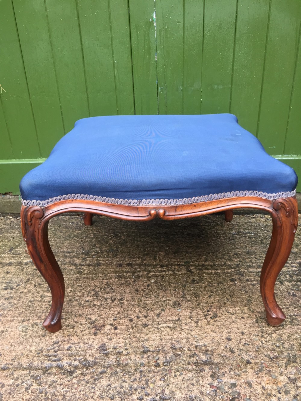 A large mid-nineteenth-century square Victorian stool featuring carved walnut cabriole legs and a blue upholstered top trimmed with gimp braid. View VII