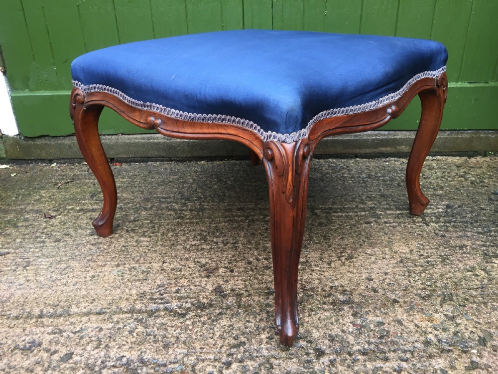 A large mid-nineteenth-century square Victorian stool featuring carved walnut cabriole legs and a blue upholstered top trimmed with gimp braid. View XII