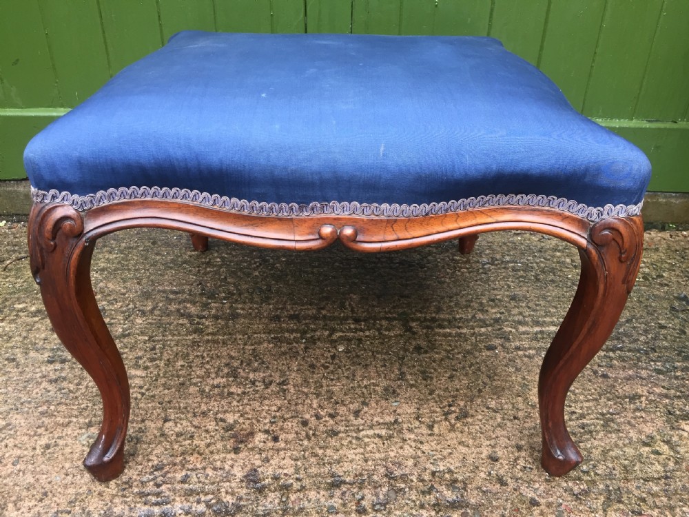 A large mid-nineteenth-century square Victorian stool featuring carved walnut cabriole legs and a blue upholstered top trimmed with gimp braid. View XVII