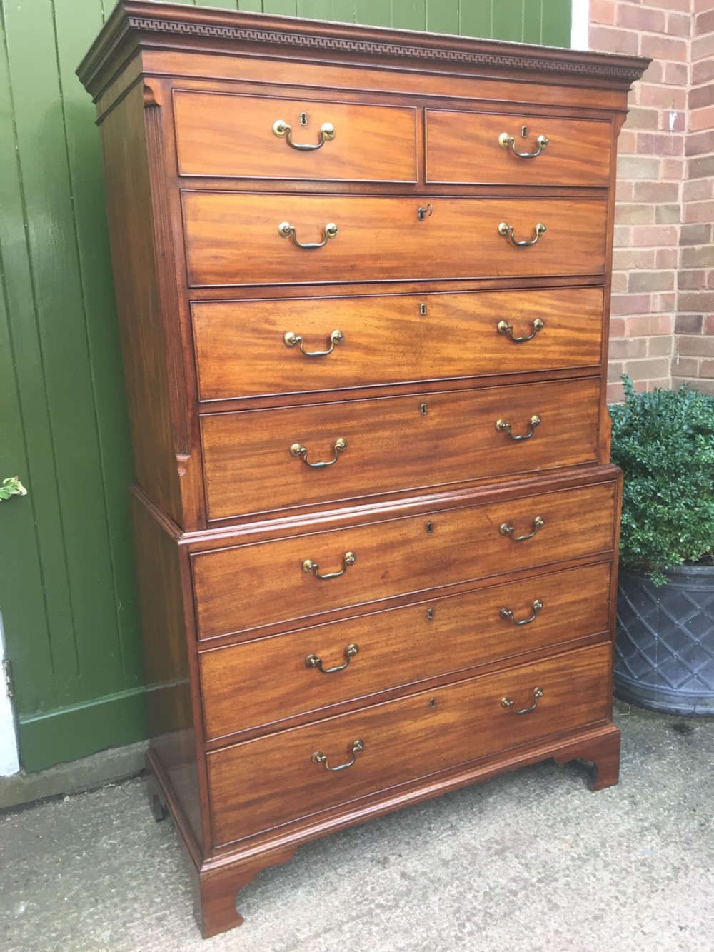 A late eighteenth-century George III mahogany chest-on-chest featuring a dentil moulding cornice, two short over five long graduated drawers with brass swan-neck handles, supported on bracket feet. View III