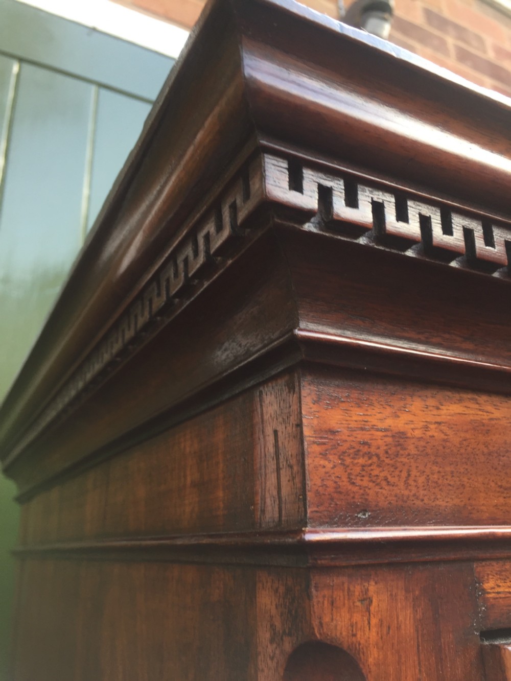A late eighteenth-century George III mahogany chest-on-chest featuring a dentil moulding cornice, two short over five long graduated drawers with brass swan-neck handles, supported on bracket feet. View VI