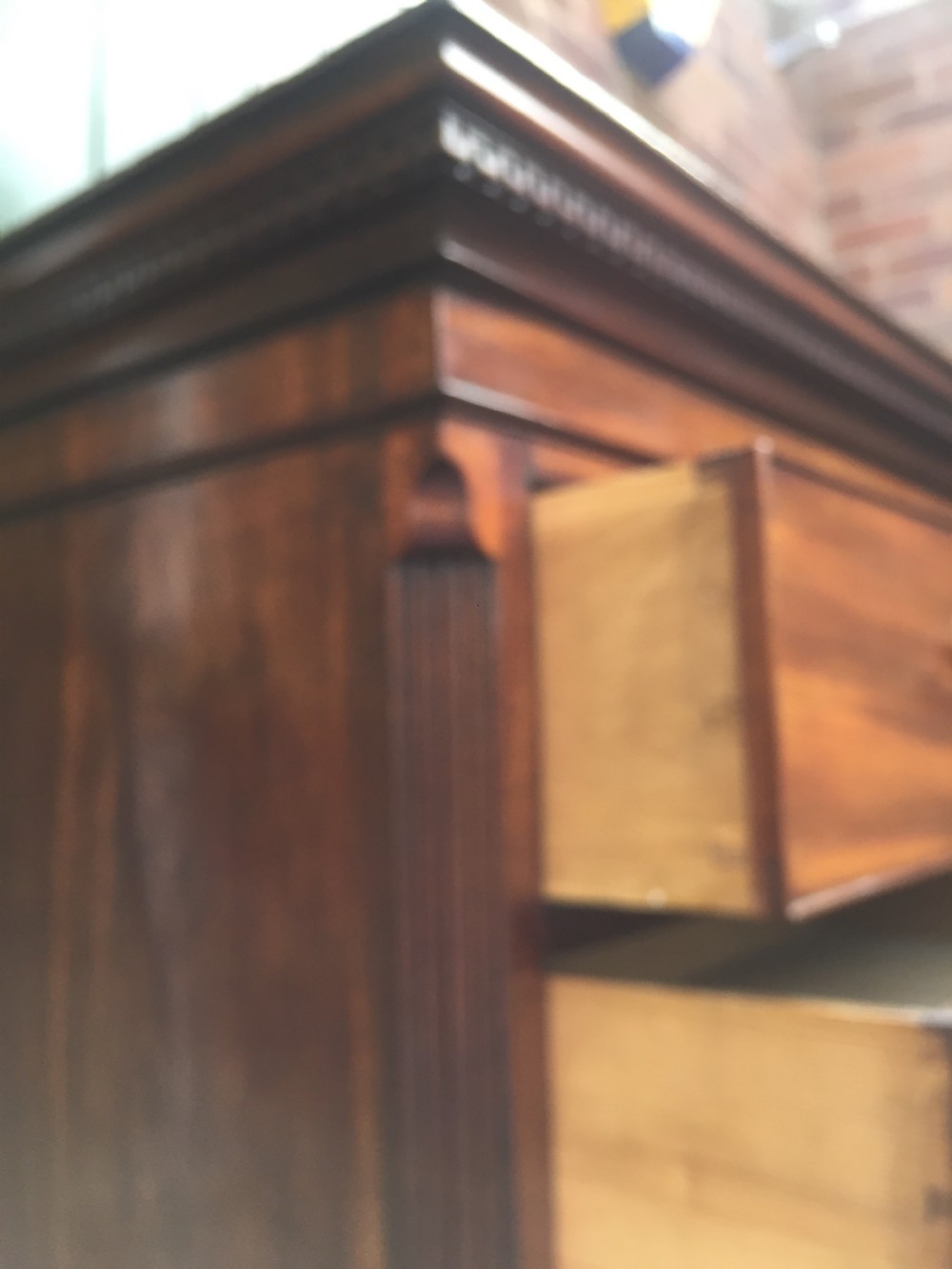 A late eighteenth-century George III mahogany chest-on-chest featuring a dentil moulding cornice, two short over five long graduated drawers with brass swan-neck handles, supported on bracket feet. View VII