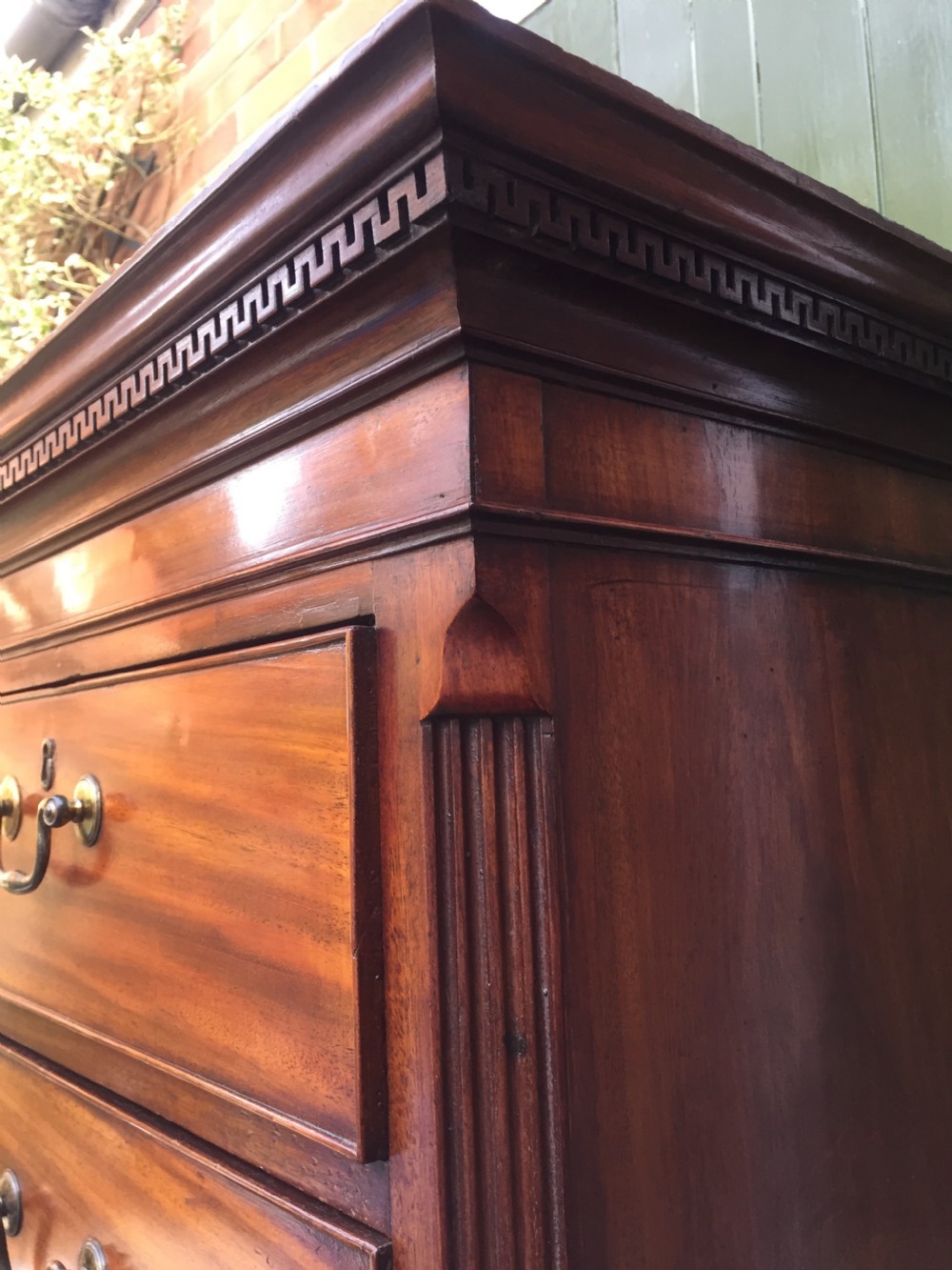 A late eighteenth-century George III mahogany chest-on-chest featuring a dentil moulding cornice, two short over five long graduated drawers with brass swan-neck handles, supported on bracket feet. View XI