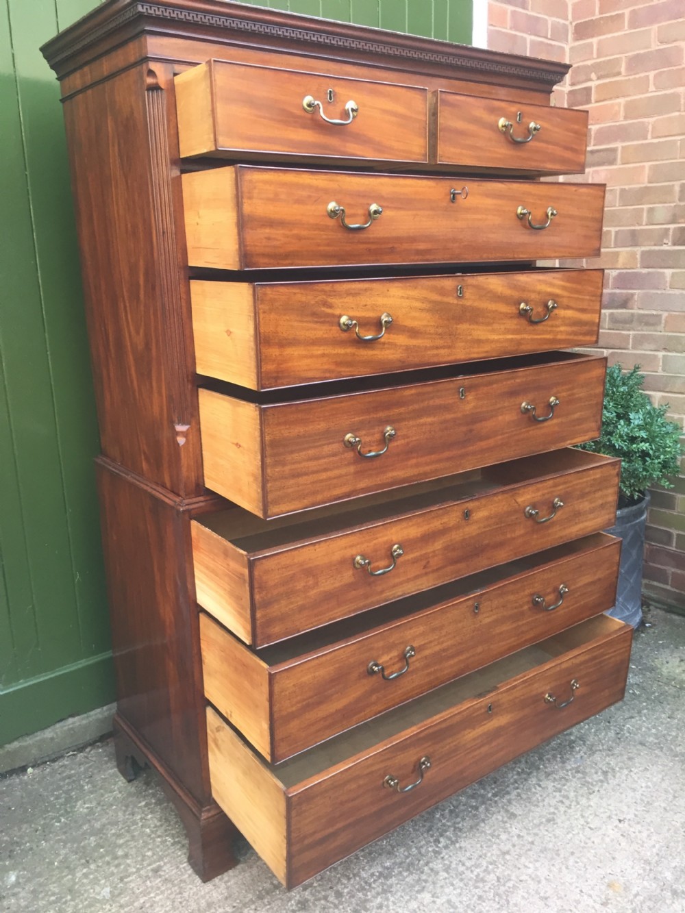 A late eighteenth-century George III mahogany chest-on-chest featuring a dentil moulding cornice, two short over five long graduated drawers with brass swan-neck handles, supported on bracket feet. View XIII