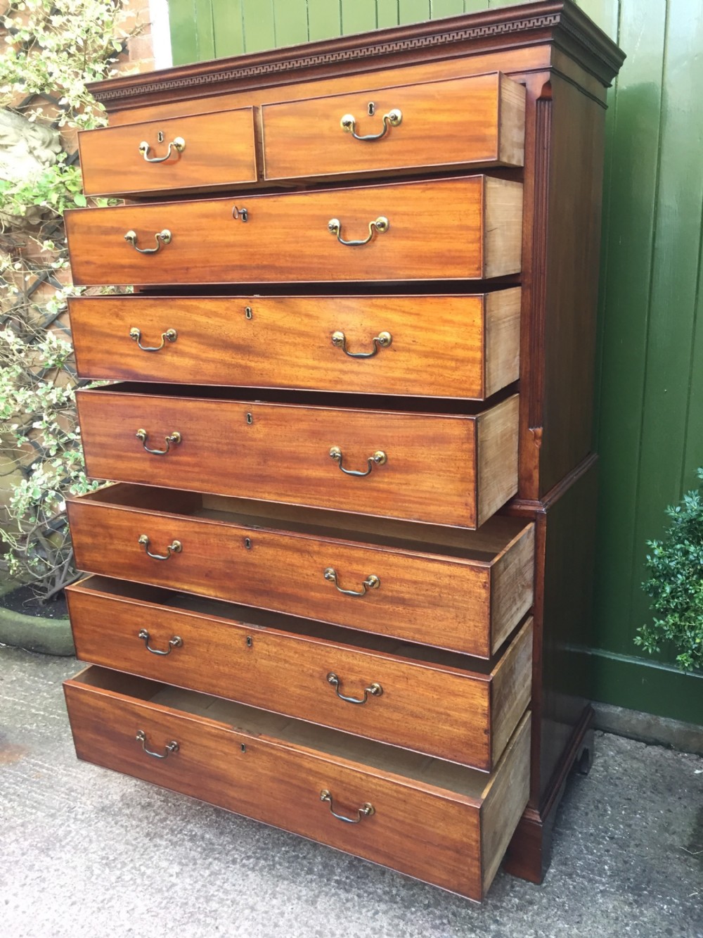 A late eighteenth-century George III mahogany chest-on-chest featuring a dentil moulding cornice, two short over five long graduated drawers with brass swan-neck handles, supported on bracket feet. View XIV
