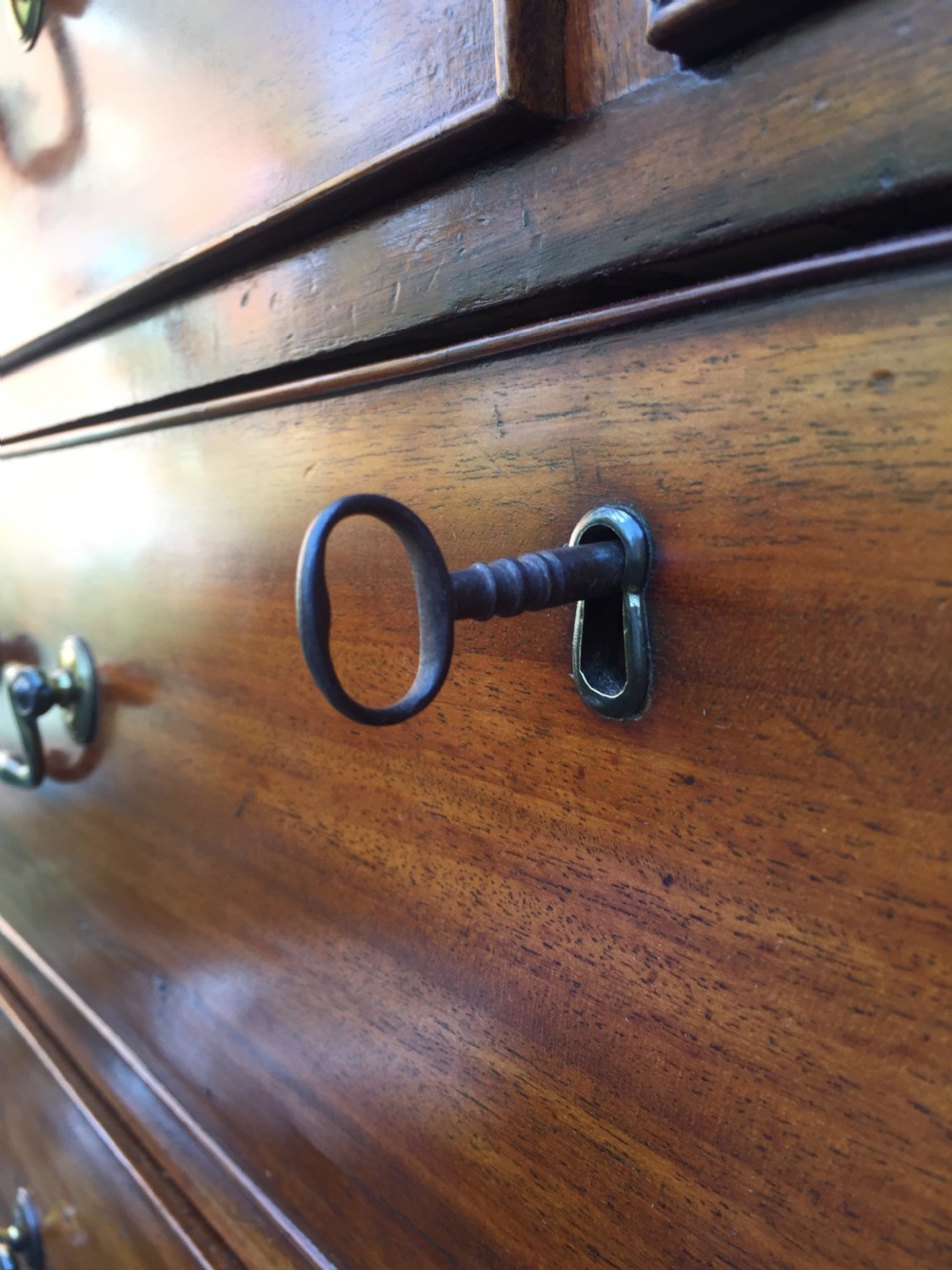 A late eighteenth-century George III mahogany chest-on-chest featuring a dentil moulding cornice, two short over five long graduated drawers with brass swan-neck handles, supported on bracket feet. View XV