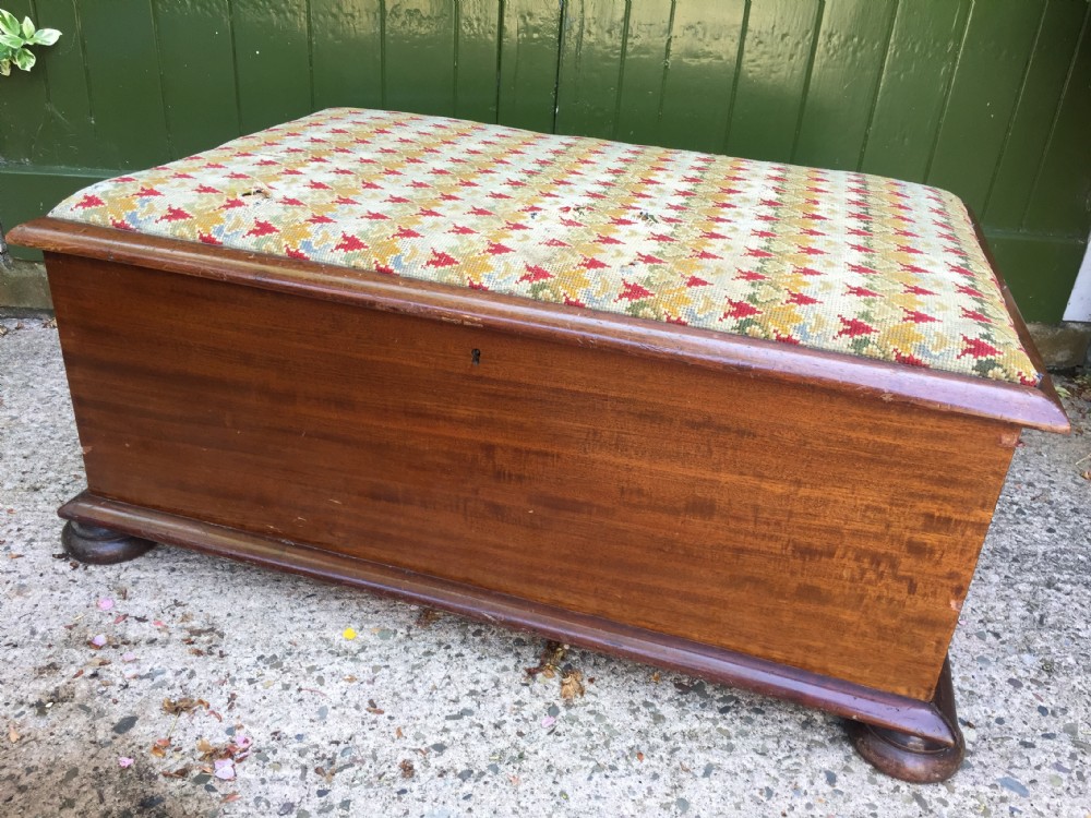 A mid-19th-century mahogany storage ottoman featuring a geometric gros-point needlework upholstered top resting on low turned bun feet. View VII