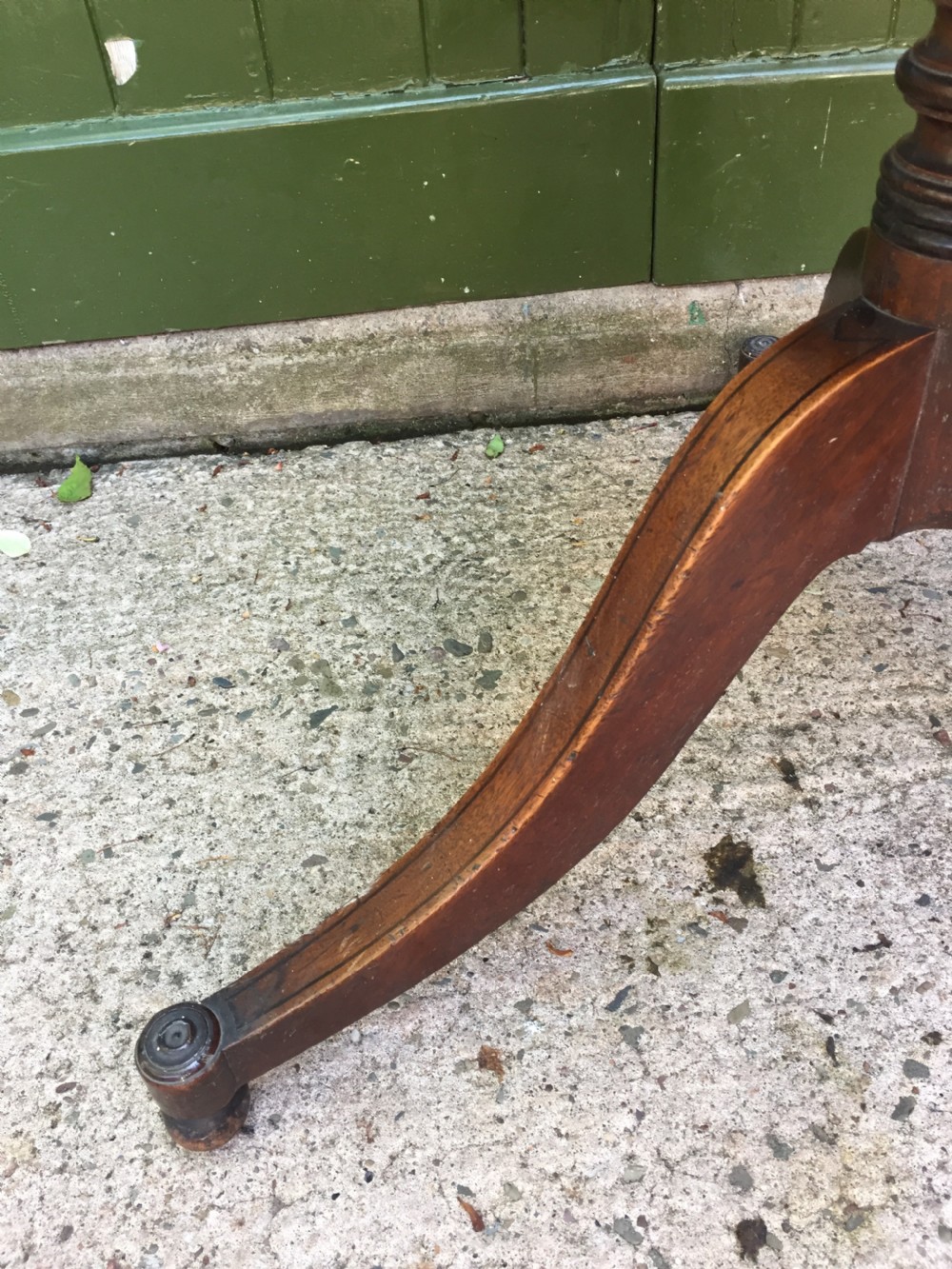 A late 18th-century George III mahogany three-tier circular dumb waiter featuring folding drop-leaf surfaces and a tripod base on castors. View V