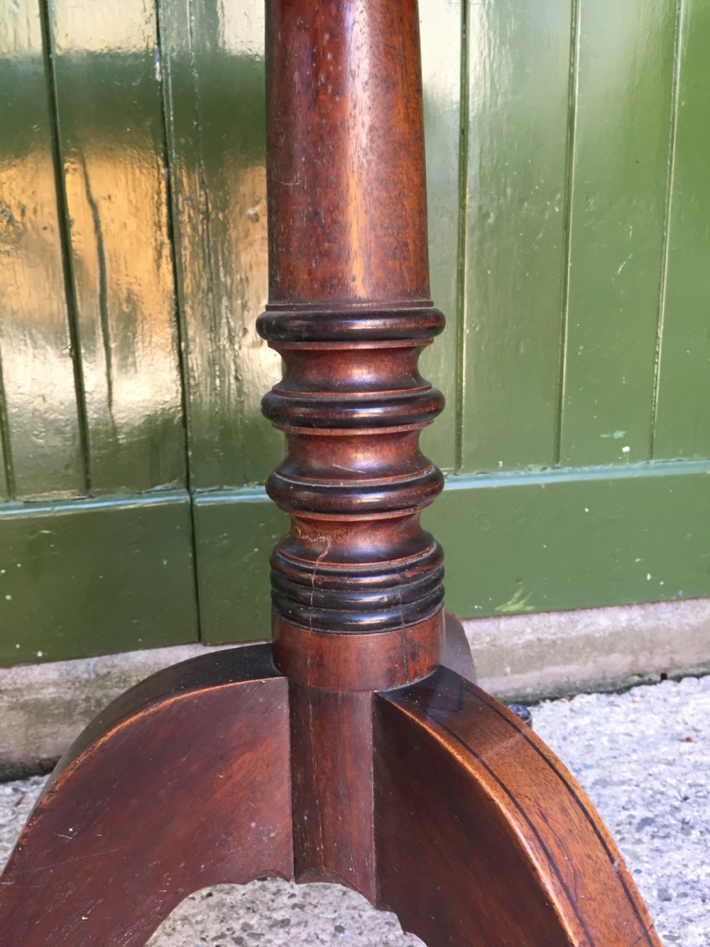 A late 18th-century George III mahogany three-tier circular dumb waiter featuring folding drop-leaf surfaces and a tripod base on castors. View XVI