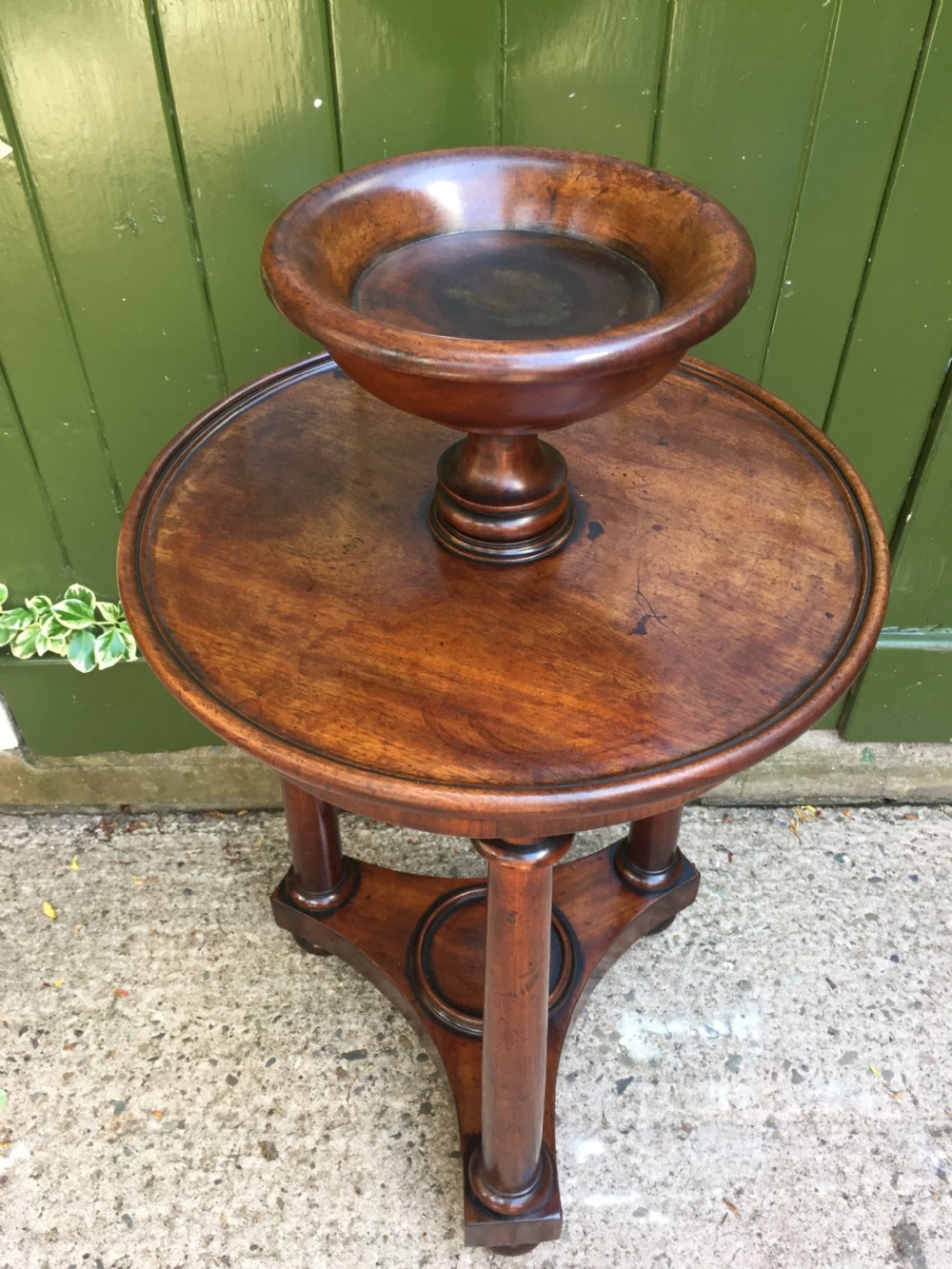 An early 19th-century French circular mahogany vide-poche table featuring a raised turned bowl, three column supports, and a triform base. View II
